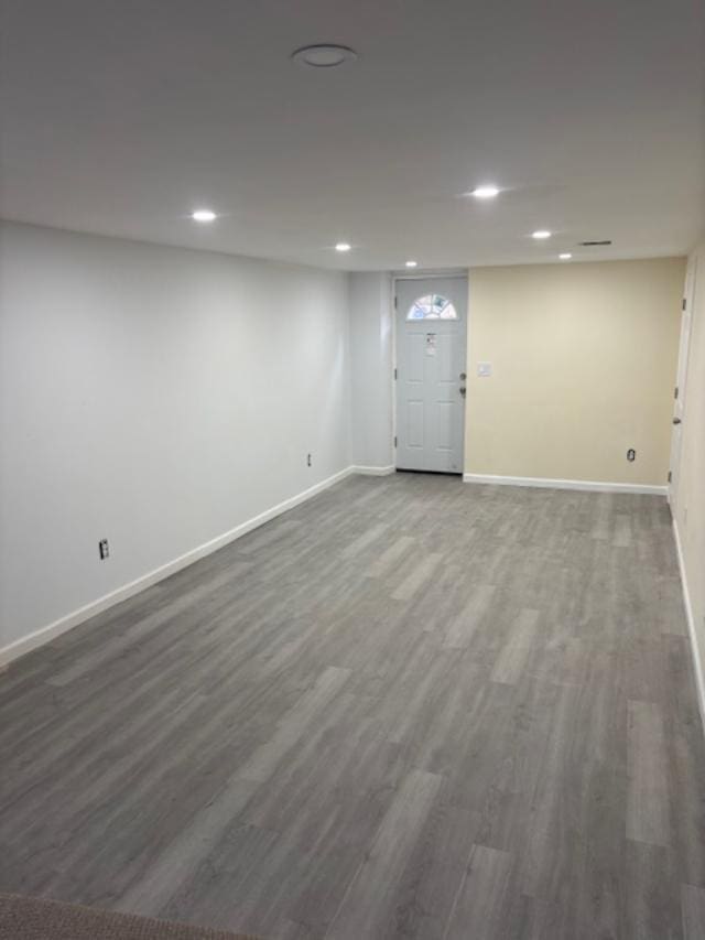 finished below grade area featuring recessed lighting, baseboards, and wood finished floors