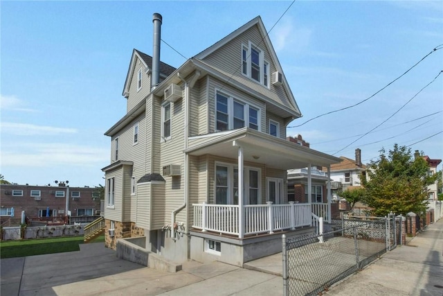 american foursquare style home with covered porch and fence