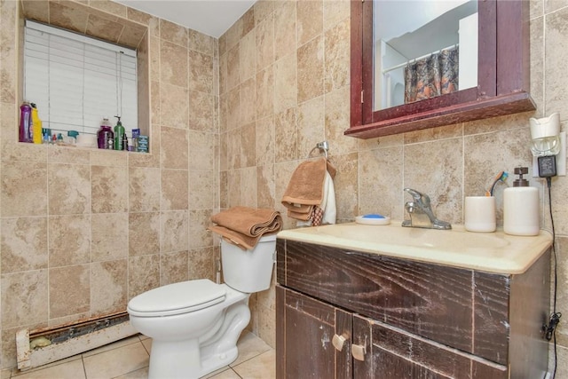 bathroom featuring toilet, vanity, tile walls, and tile patterned floors