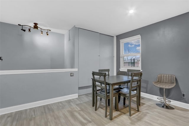 dining space with light wood-style floors and baseboards