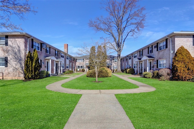 view of property's community featuring a lawn and a residential view