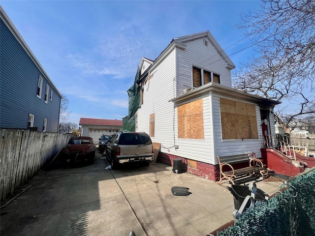 view of side of property featuring an outbuilding and fence