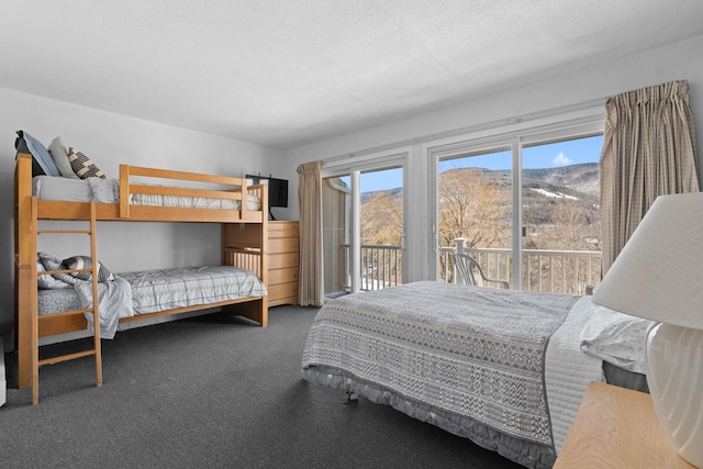 carpeted bedroom with access to outside, a mountain view, and a textured ceiling