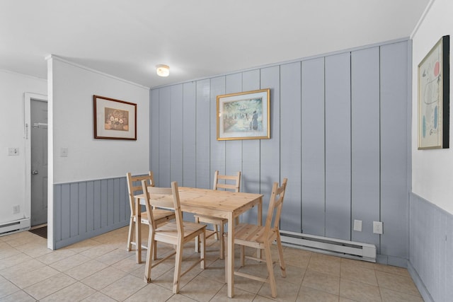 dining space with light tile patterned floors, baseboard heating, and crown molding