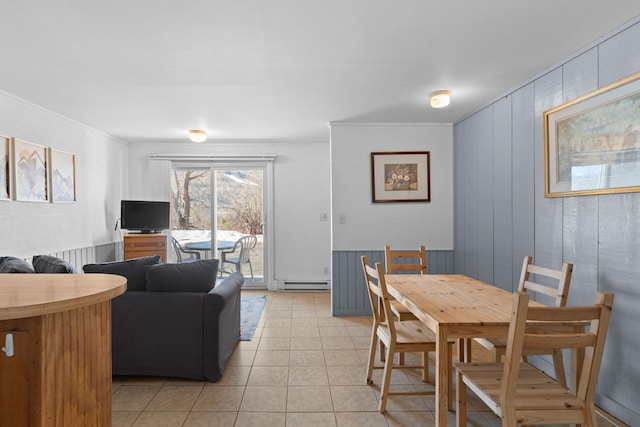 dining room featuring baseboard heating, light tile patterned flooring, and crown molding