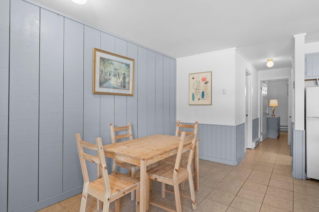 dining area featuring crown molding and light tile patterned flooring