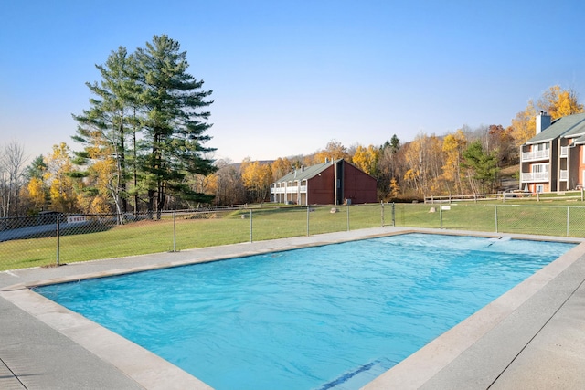 view of swimming pool featuring a fenced in pool, fence, and a lawn