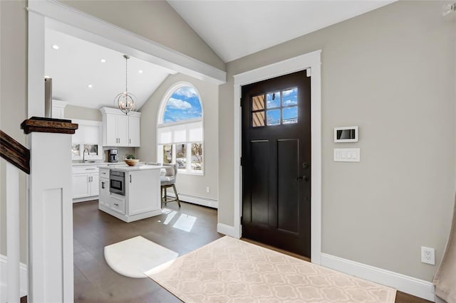 entryway with recessed lighting, a baseboard heating unit, a notable chandelier, baseboards, and vaulted ceiling