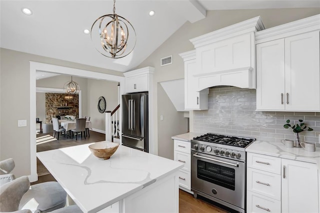 kitchen with premium appliances, a notable chandelier, visible vents, backsplash, and lofted ceiling with beams