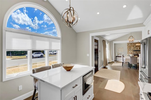 interior space featuring baseboards, wood finished floors, vaulted ceiling, a chandelier, and recessed lighting