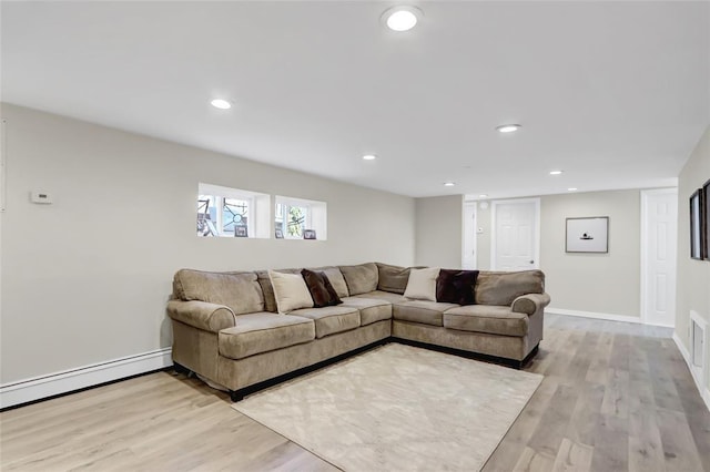 living area with light wood-type flooring, baseboards, a baseboard heating unit, and recessed lighting