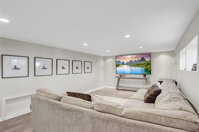 living room featuring light wood finished floors, baseboards, and recessed lighting