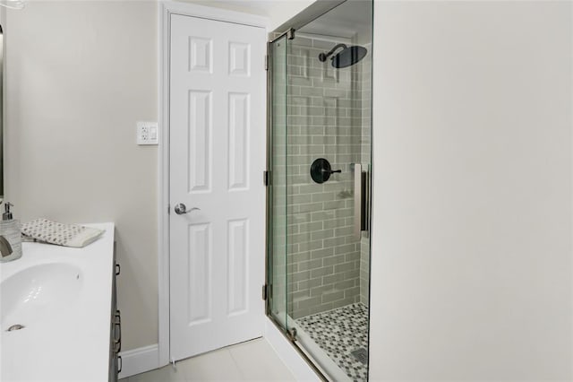 bathroom with tile patterned flooring, a shower stall, and vanity