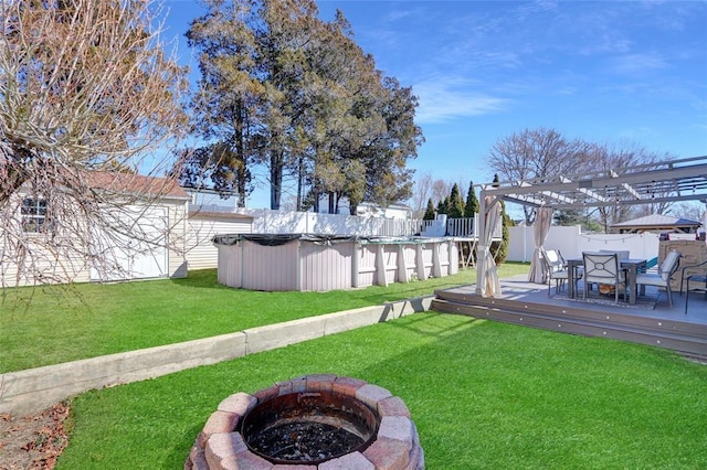 view of yard featuring a fenced in pool, a pergola, a fenced backyard, a fire pit, and a wooden deck