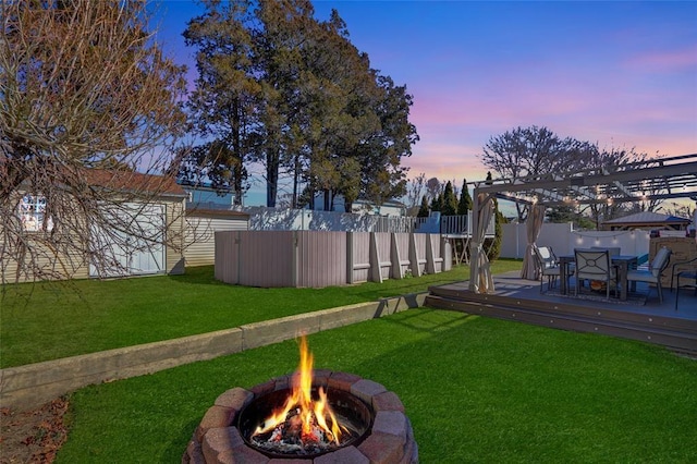 view of yard with an outdoor fire pit, a fenced backyard, and a wooden deck