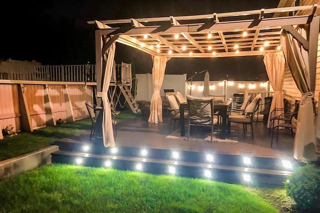 patio at twilight with fence and a pergola