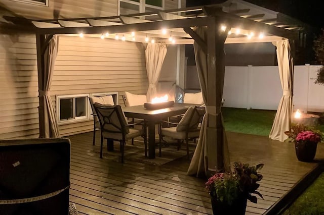 wooden deck featuring outdoor dining space, fence, and a pergola