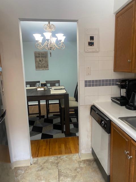 kitchen with electric panel, white dishwasher, and brown cabinets