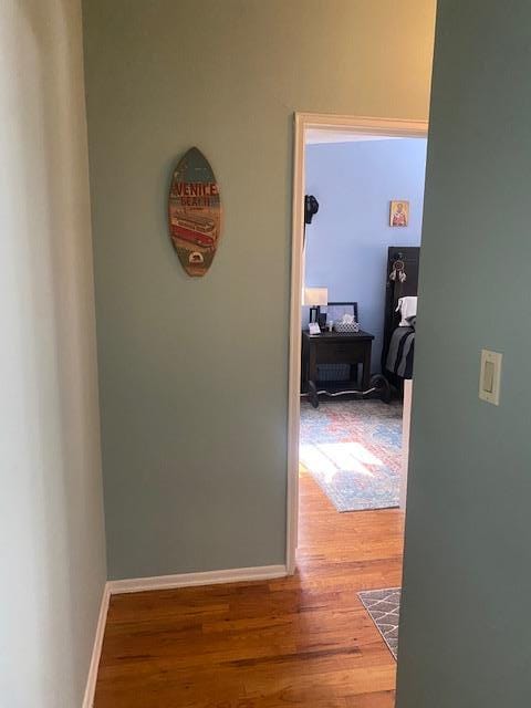 hallway with baseboards and wood finished floors