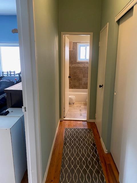 corridor featuring wood finished floors and baseboards