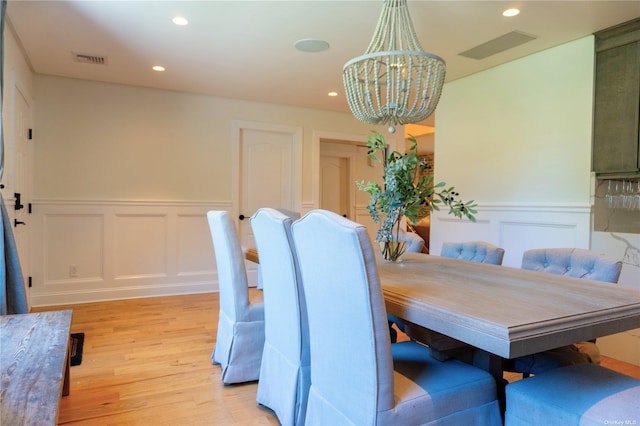 dining area with light wood-style flooring, recessed lighting, a wainscoted wall, a notable chandelier, and visible vents