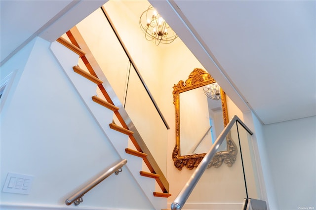 staircase with an inviting chandelier