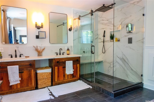 full bathroom featuring a marble finish shower, decorative backsplash, and a sink