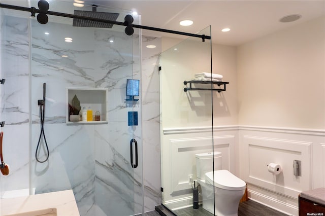 full bath with a wainscoted wall, a marble finish shower, recessed lighting, a decorative wall, and toilet