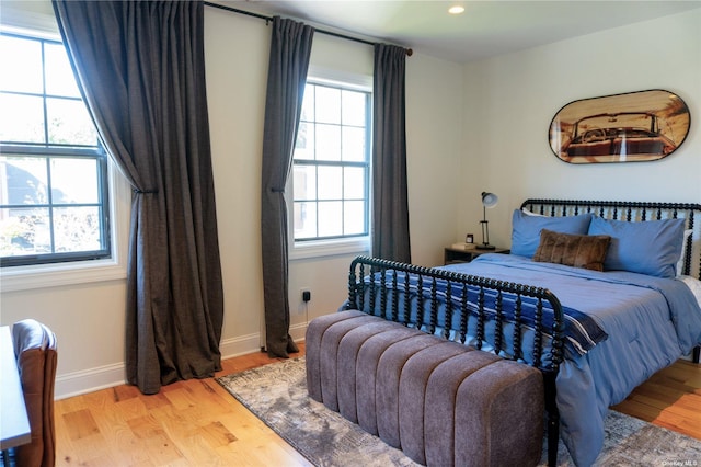 bedroom with light wood-type flooring, baseboards, and recessed lighting