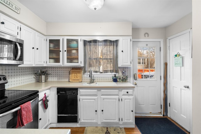 kitchen featuring backsplash, white cabinets, stainless steel appliances, and light countertops