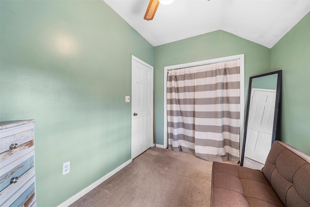 interior space featuring baseboards, lofted ceiling, a ceiling fan, and carpet flooring