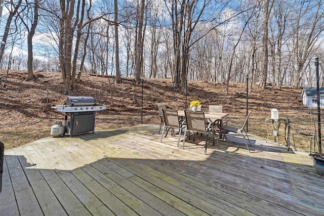 wooden deck with outdoor dining space and a grill