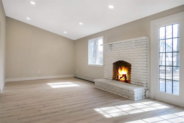 unfurnished living room with recessed lighting, light wood-style flooring, baseboard heating, a brick fireplace, and vaulted ceiling