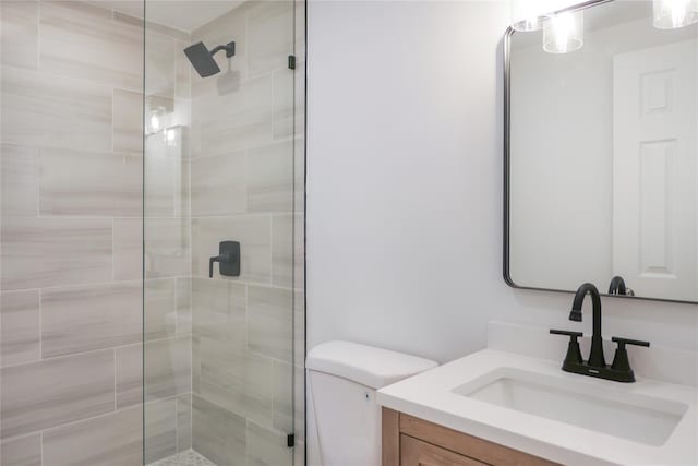 bathroom featuring toilet, a stall shower, and vanity