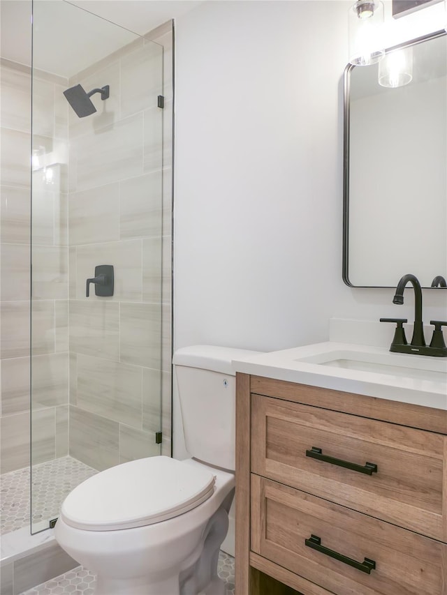 full bathroom featuring a stall shower, vanity, and toilet