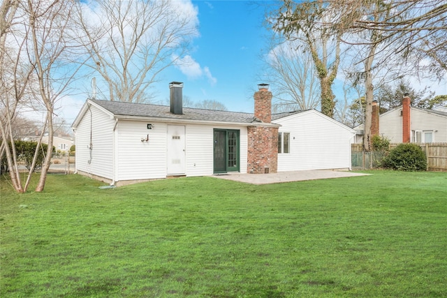 back of property with a yard, a shingled roof, a patio, and fence