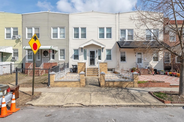 townhome / multi-family property with entry steps and a fenced front yard