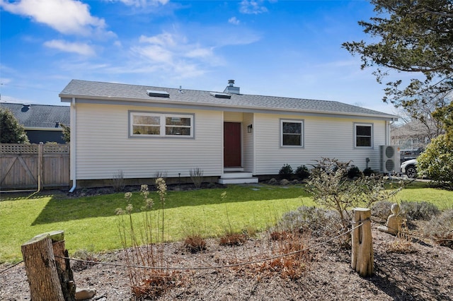 view of front of home with entry steps, a front lawn, and fence