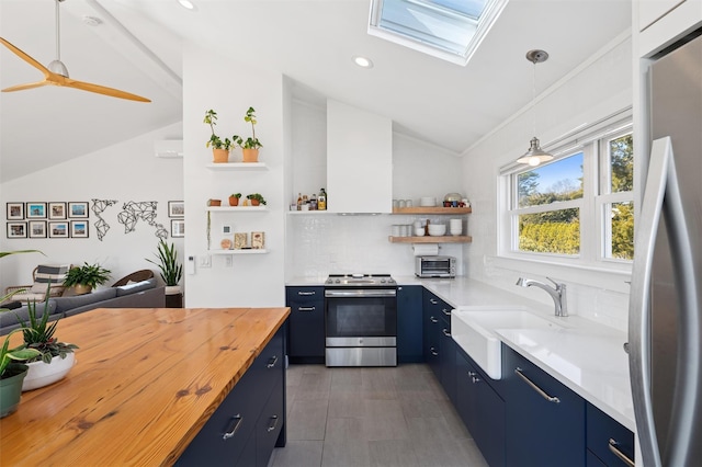 kitchen featuring blue cabinetry, wooden counters, and stainless steel appliances