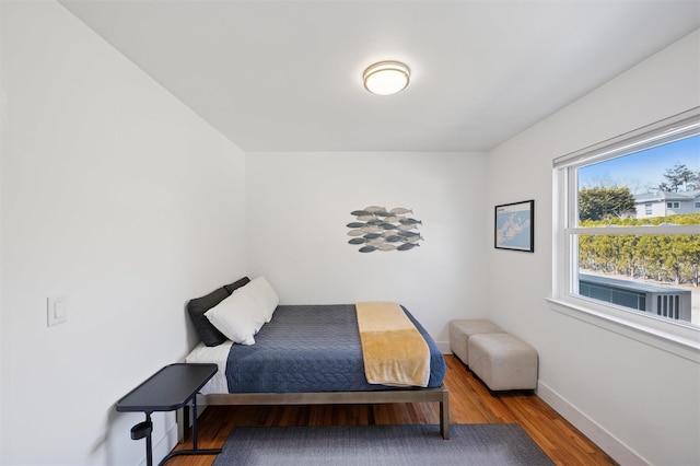 bedroom with wood finished floors and baseboards