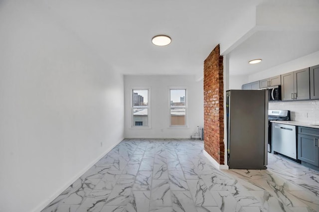 kitchen with marble finish floor, stainless steel appliances, light countertops, decorative backsplash, and baseboards