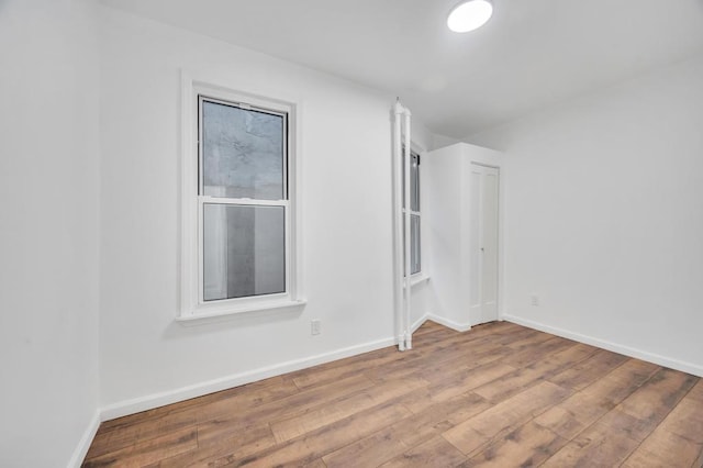 unfurnished room featuring wood-type flooring and baseboards