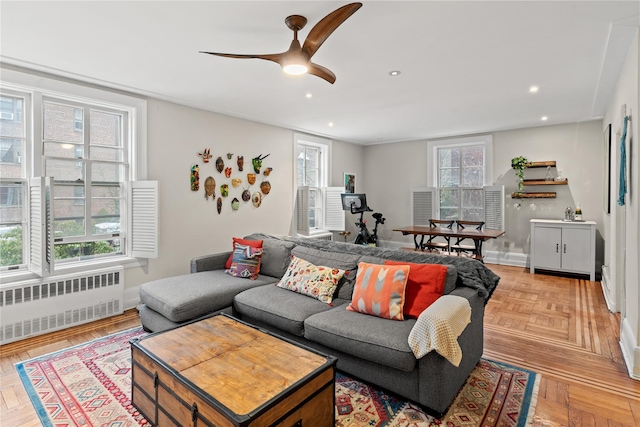 living room featuring ceiling fan, radiator heating unit, baseboards, and recessed lighting