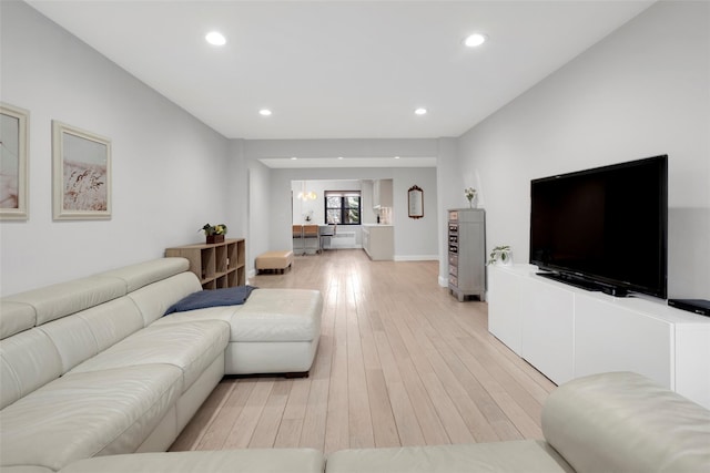 living area featuring light wood-type flooring, baseboards, and recessed lighting