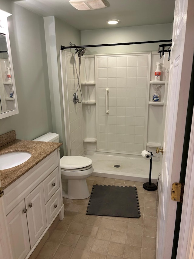 full bath with a stall shower, vanity, and toilet