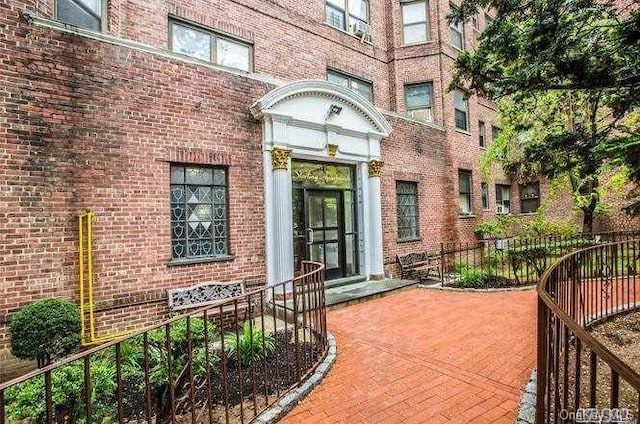 view of exterior entry featuring brick siding