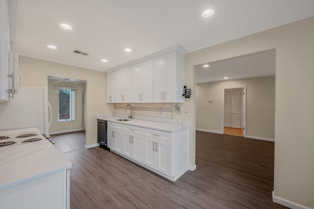 kitchen featuring white appliances, visible vents, a sink, and white cabinetry