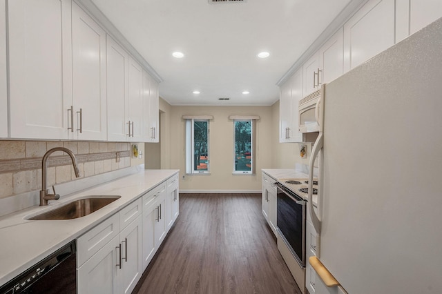 kitchen featuring white appliances, a sink, white cabinets, decorative backsplash, and dark wood finished floors