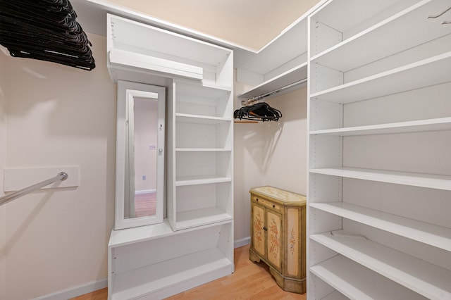 walk in closet with wood finished floors