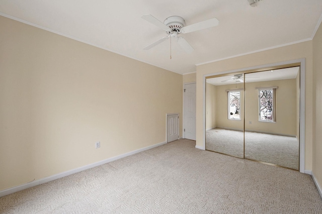 unfurnished bedroom featuring baseboards, ceiling fan, ornamental molding, carpet, and a closet